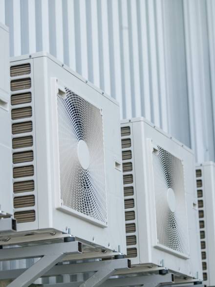 A closeup of air conditioners installed on the outside wal